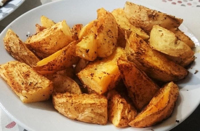Tray of rustic skin on roasted potatoes, golden and seasoned with oregano and merken