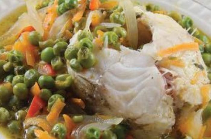 Deep plate of Chilean arvejado de rollizo, a sandperch fish stew with green peas and vegetables