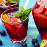 Chilean-style sangria in a pitcher with floating fruit, served with ice.