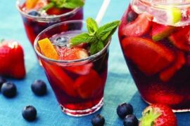 Chilean-style sangria in a pitcher with floating fruit, served with ice.