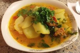 Chilean smoked longaniza soup with potatoes and noodles in a deep bowl