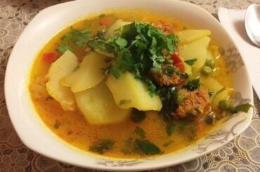 Chilean smoked longaniza soup with potatoes and noodles in a deep bowl