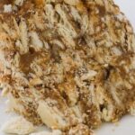 Slice of Chilean soda cracker cake layered with manjar and jam, a no-bake dessert dusted with powdered sugar