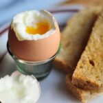 Chilean soft-boiled eggs in egg cups with toast and runny yolks
