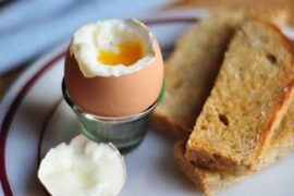 Chilean soft-boiled eggs in egg cups with toast and runny yolks