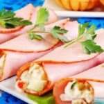 Ham rolls stuffed with egg and mayonnaise on a bed of lettuce