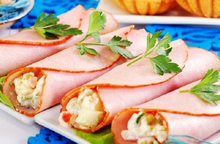 Ham rolls stuffed with egg and mayonnaise on a bed of lettuce