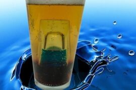 Chilean submarino cocktail, a mint liqueur shot glass sunk inside a tall glass of cold Pilsner beer.