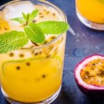 Refreshing tropical gin and passion fruit cocktail in a tall glass, garnished with a pineapple slice and passion fruit seeds.