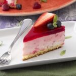 Chilean yogurt and sponge cake with a bright red gelatin top and fresh strawberries inside