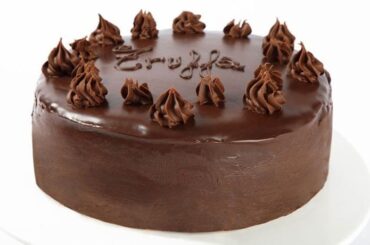Chocolate truffle cake covered in ganache and decorated with sprinkles