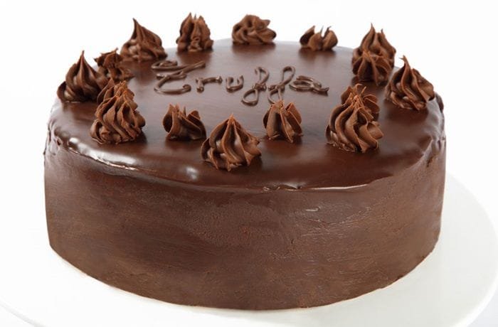 Chocolate truffle cake covered in ganache and decorated with sprinkles