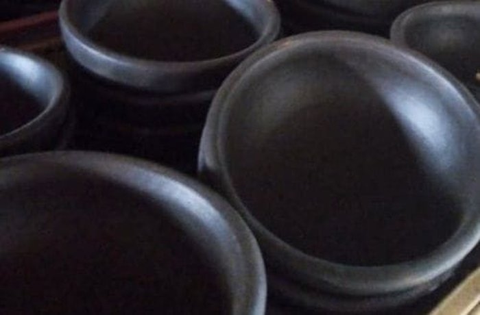 Four individual clay dishes, ready to assemble the pastel de chuchoca.