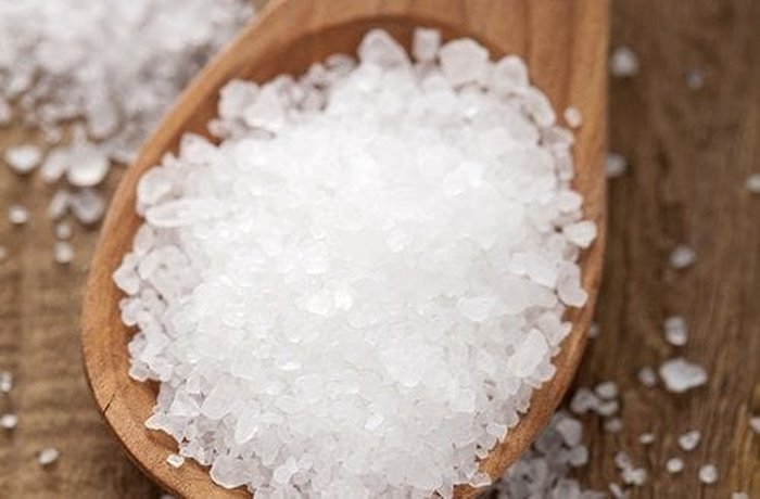 Coarse salt on a measuring spoon, ready for the mustard and herb rub of the roast beef