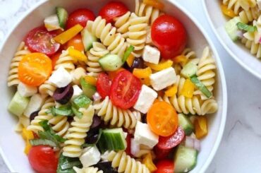 Cold spiral pasta salad with spinach, cherry tomatoes, and mozzarella