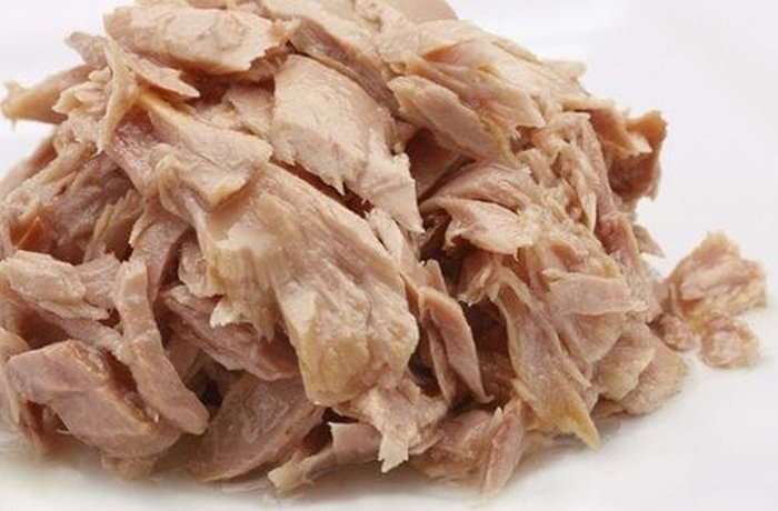 Canned tuna well drained and flaked in a bowl, ready for the antipasto