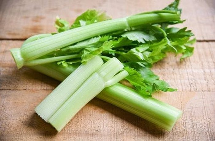 Fresh celery leaves and stalks in a bowl, the main flavor ingredient of this mayonnaise