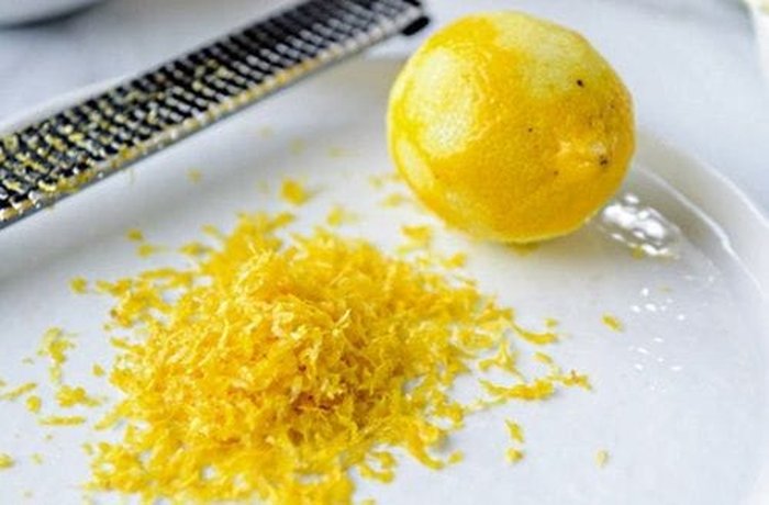 Fresh lemon zest grated onto a plate for Chilean lemon cookies