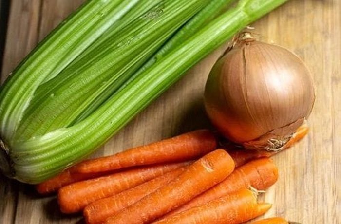 A set of fresh, chopped aromatic vegetables, ready to flavor the pig's feet broth.