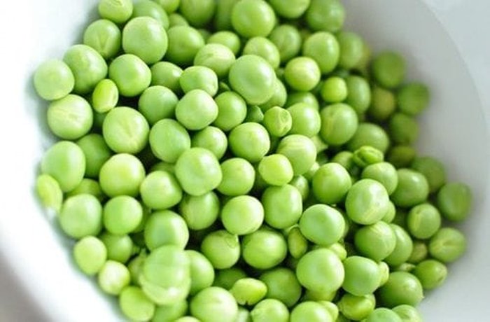 Fresh green peas in a pot, ready to be cooked for the arvejado