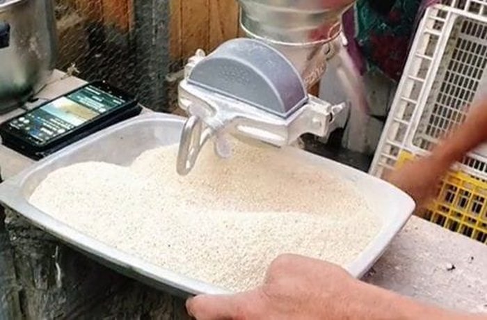 Grinding toasted wheat grains by hand into fine flour