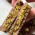 Homemade Dubai chocolate bar broken open to show the green pistachio and kataifi filling