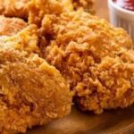 Homemade KFC-style crispy fried chicken pieces with a thick, craggy crust