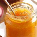 Homemade passion fruit jam in a glass jar with a bright, glossy texture