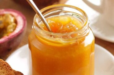 Homemade passion fruit jam in a glass jar with a bright, glossy texture