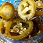 Homemade pickled jalapeno slices in a glass jar
