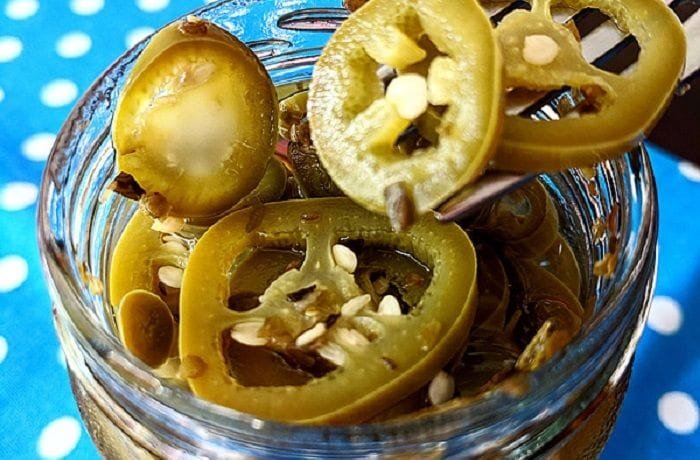 Homemade pickled jalapeno slices in a glass jar