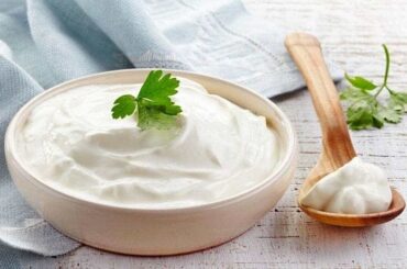 Homemade crema acida in a white ceramic bowl with a pinch of merken and pepper