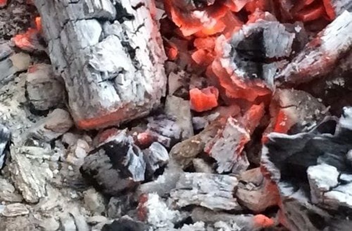 Hot charcoal embers ready for grilling the pre-cooked beef udder strips