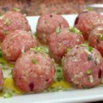 Kibbeh nayyeh spread on a plate, garnished with fresh mint, olive oil, and lemon slices.