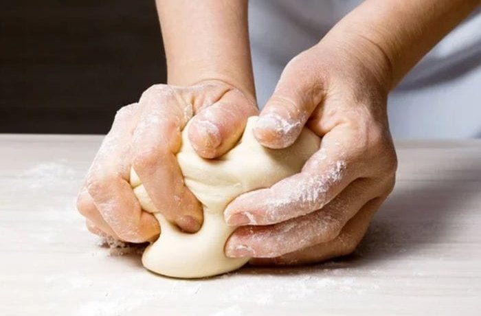 Kneading the pan coliza dough until smooth and elastic.