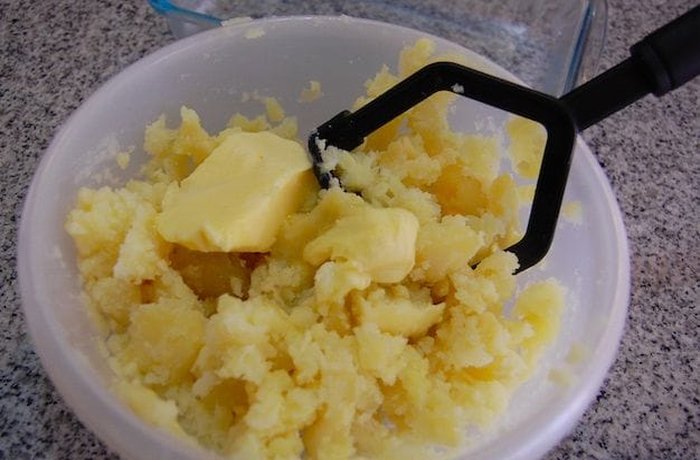 Mashing boiled potatoes for gnocchi dough
