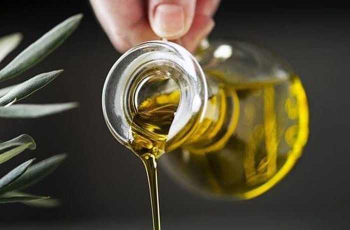 Olive oil being poured slowly, the fat that emulsifies the homemade celery mayonnaise