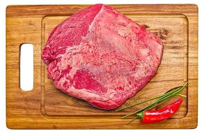 Raw asado carnicero beef cut rubbed with adobo, ready for the grill