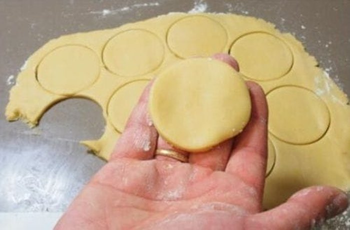 Gluten-free hojarasca dough being rolled out and cut into perfect circles.