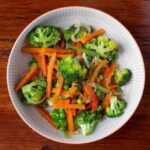 Colorful sautéed vegetables with broccoli, peppers, carrots, and peas
