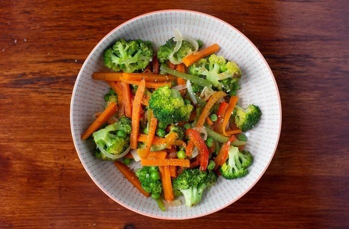 Colorful sautéed vegetables with broccoli, peppers, carrots, and peas