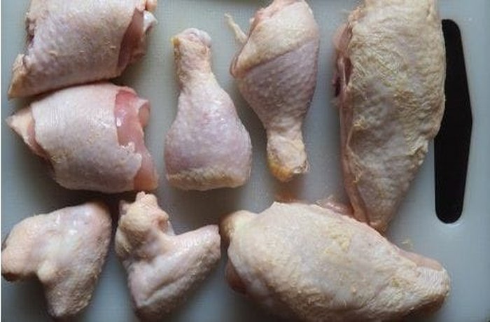 Chicken pieces seasoned with lemon and spices, ready to be browned.