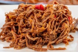 Shredded beef ropa vieja in tomato hogao sauce served with white rice