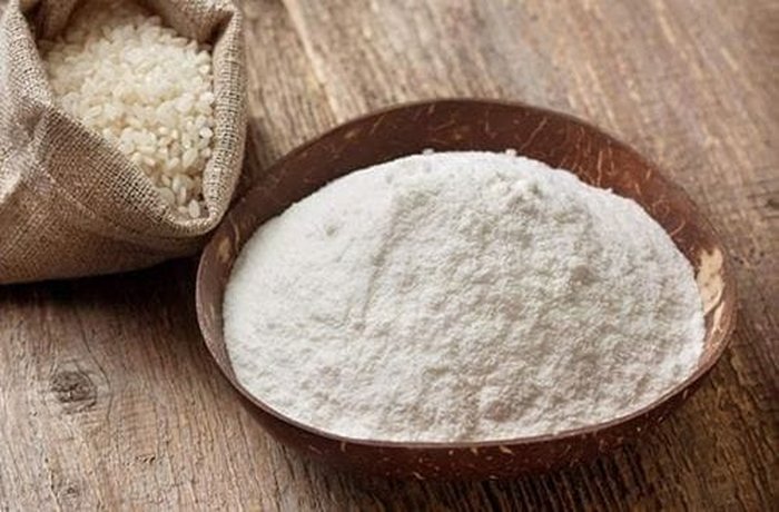 Fine rice flour sifted into a bowl along with cornstarch and potato starch for the gluten-free dough.