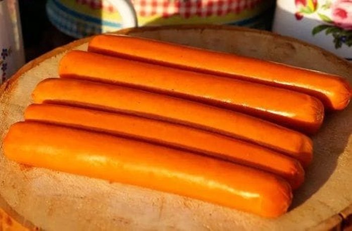 Hot dog sausages sliced diagonally, ready to fry for salchipapas