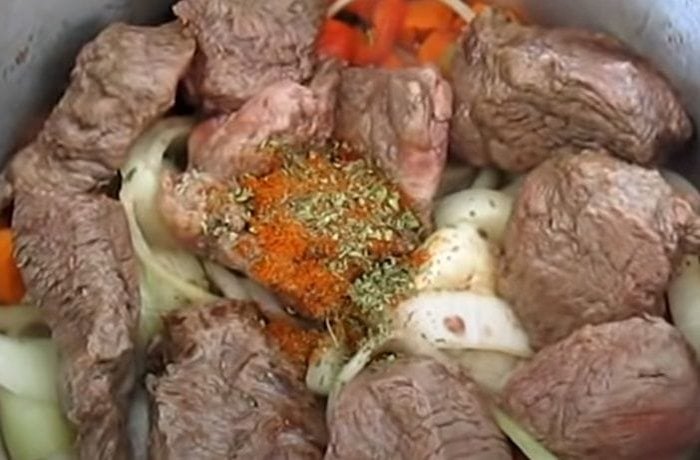 Carne al jugo slow cooking in a covered pot with carrots and all the ingredients