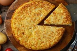 Golden Spanish potato omelette, tortilla de papas, sliced on a plate