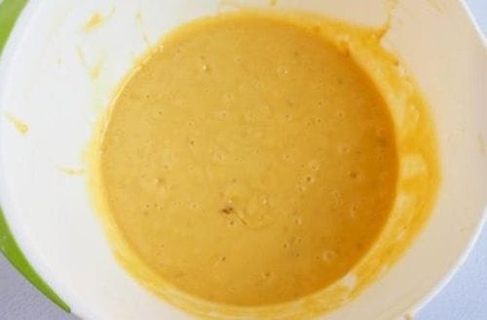 Light sponge cake batter spread evenly in a round cake tin