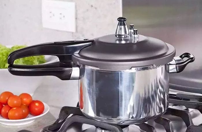 A silver stovetop pressure cooker, the key tool for tenderizing tough cuts like brisket.