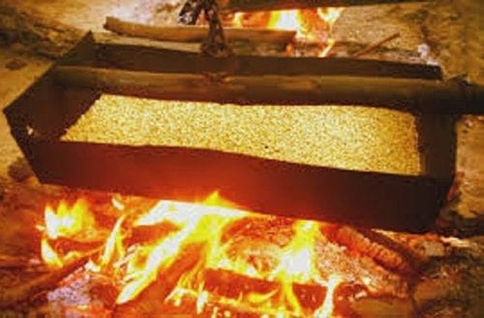 Toasting wheat in a traditional clay callana over an open flame